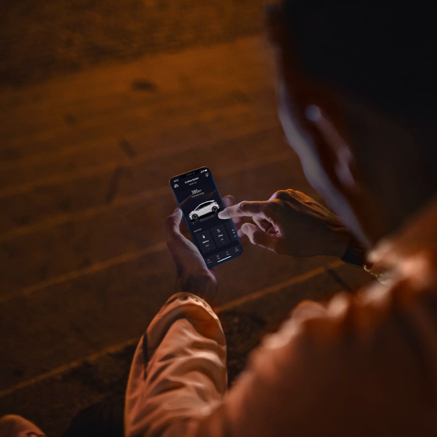 woman with a smartphone in an urban environment, representing international customer care for cupra leon