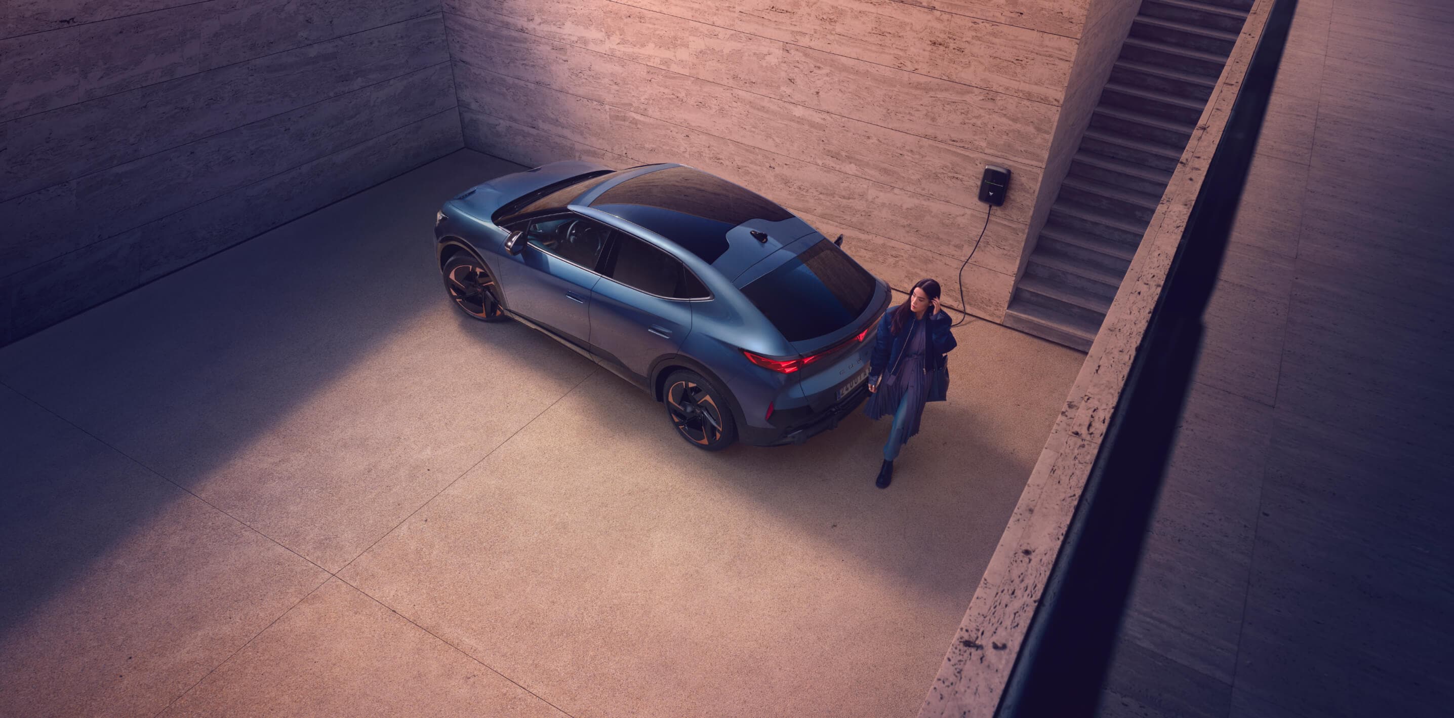 magnetic tech grey cupra formentor charging with man outside waiting